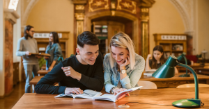 dwoje studentów w czytelni pochyla się nad ksiązką
